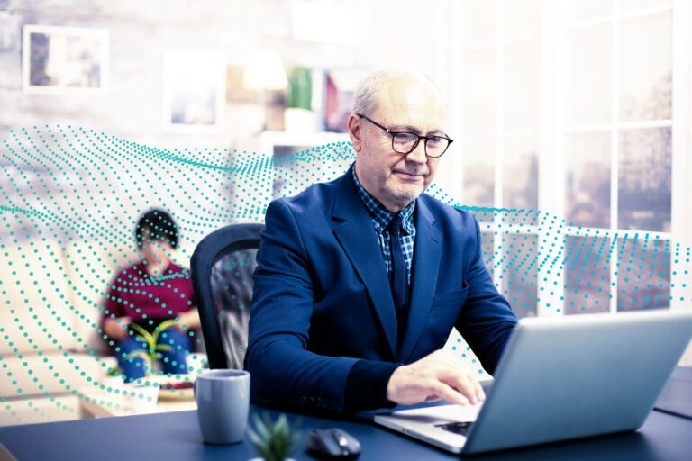 Man working at a laptop with a brand pattern in the background