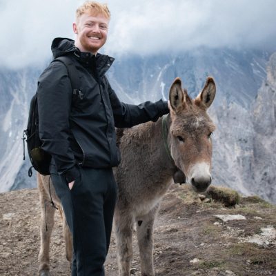 Brad standing next to a donkey in the Dolomites, Italy