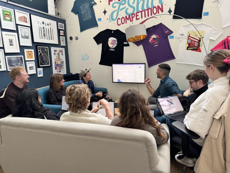 The Fanatic team gathered in the studio for an in-house Looker Studio training session, with laptops open and a dashboard displayed on the screen