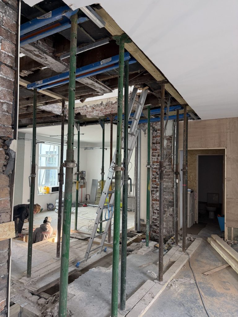 Courage House mid-renovation, with structural props supporting the ceiling while builders work on opening up the space