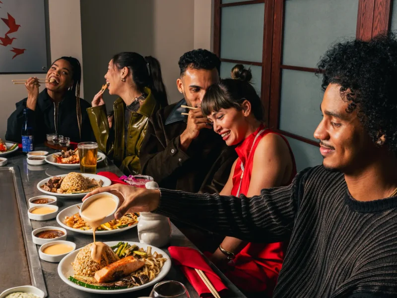 Group of people eating at a tepenyaki grill and having a great time