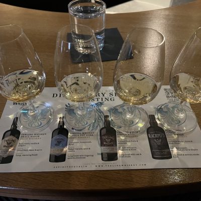 4 Whisky glasses lined up for a tasting. Each glass has a small amount of whisky in.