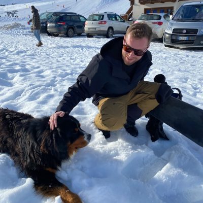Ben stroking a dog in the snow